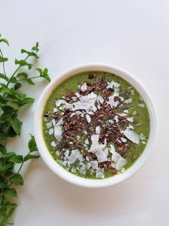 mint chocolate chip smoothie bowl with mint on side