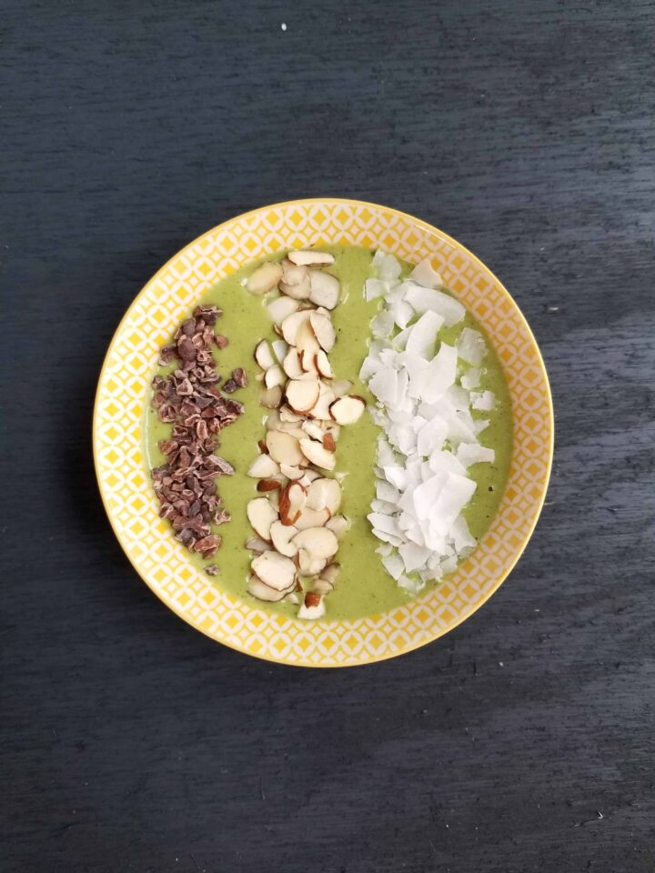 Green smoothie bowl with almond joy toppings